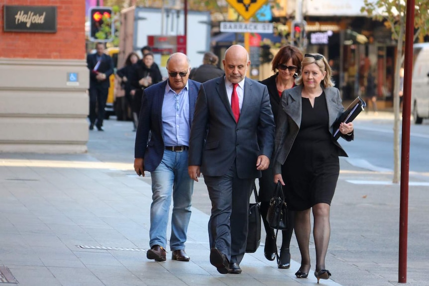 Lisa Scaffidi walks along side her lawyer down a city street.