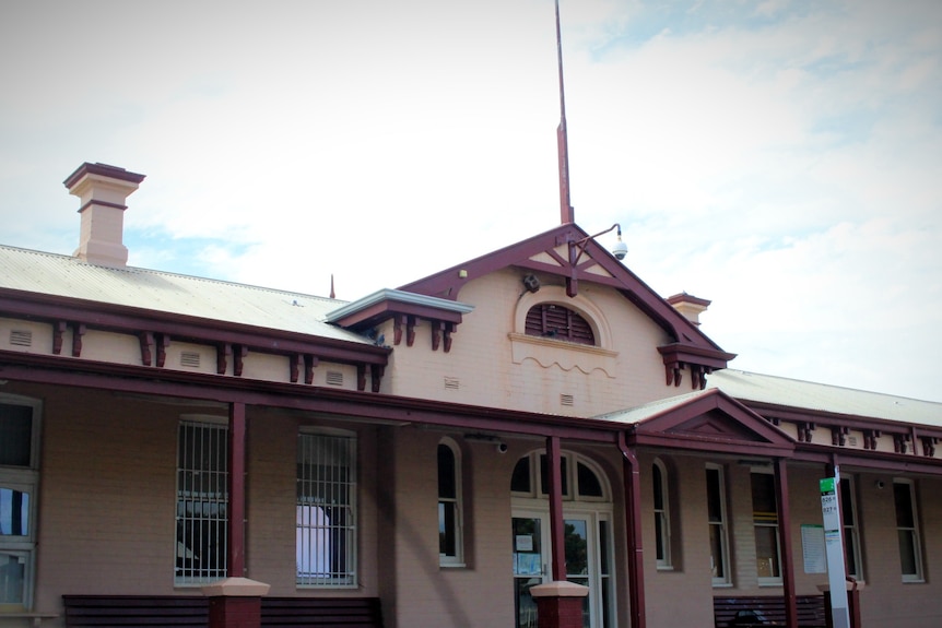 An old pink-coloured railway station building.