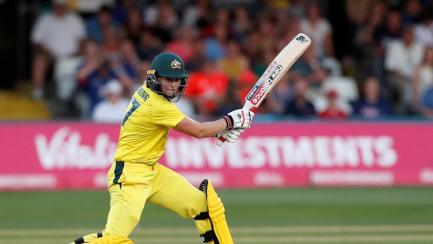Australia's Meg Lanning hits the ball dressed in yellow.