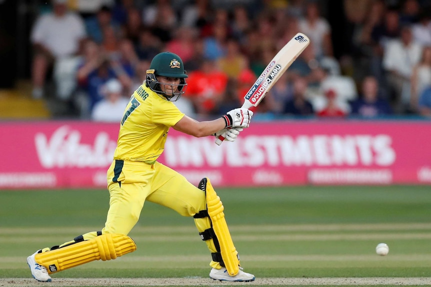 Australia's Meg Lanning hits the ball dressed in yellow.