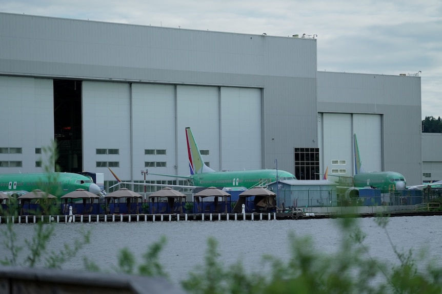 Aeroplanes outside a plane warehouse.