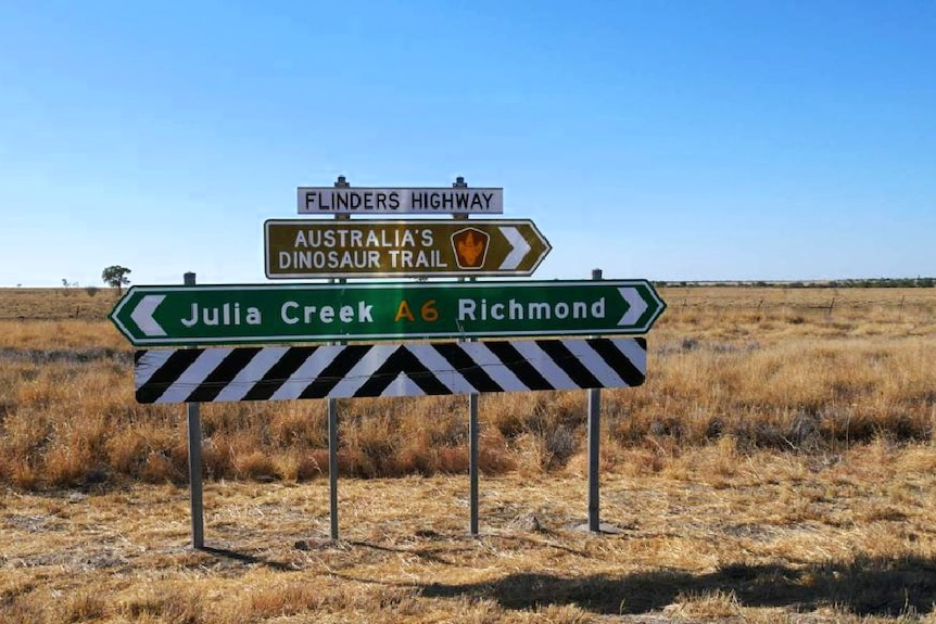 A highway sign with 'Julia Creek' in one direction and 'Richmond' in the other