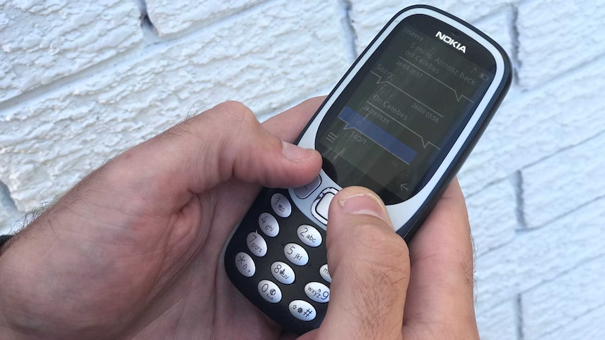 Richard Scott sending a text on his Nokia 3310 old school mobile phone. He has no social media