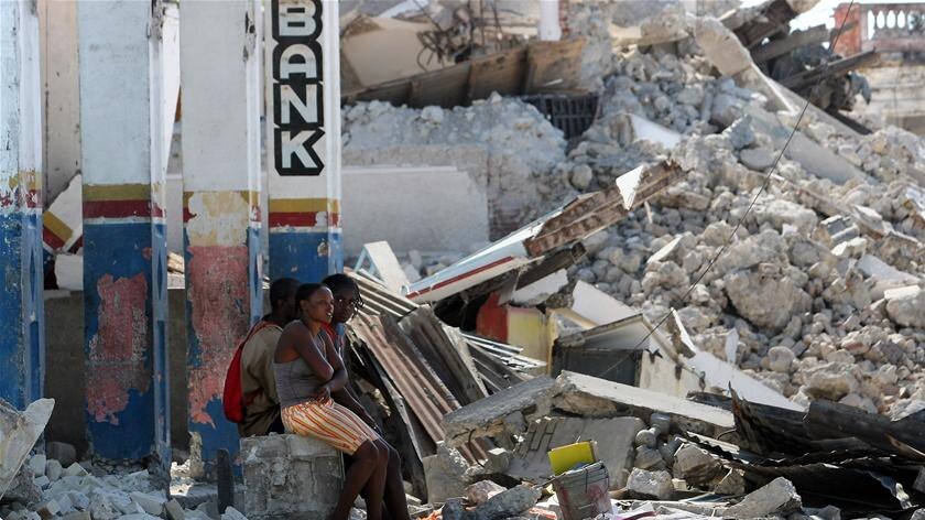 Haitians sit in the rubble of a destroyed church