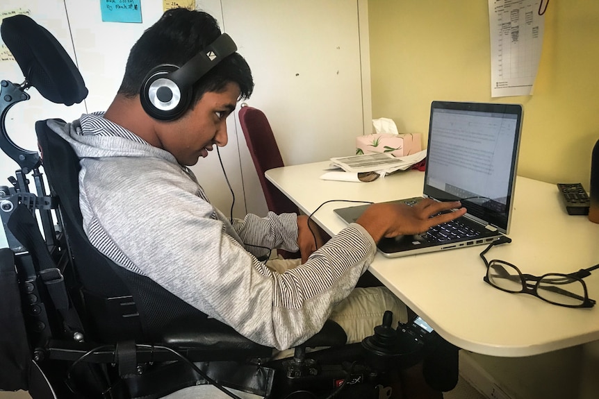 An 18-year-old student sits at his desk and types on a laptop during coronavirus restrictions