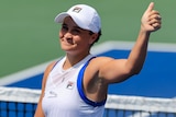 Ash Barty smiles and gives a thumbs up to the crowd