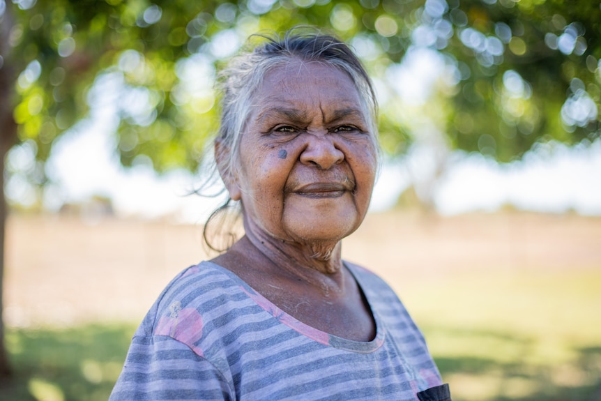 una mujer aborigen mirando a la cámara.