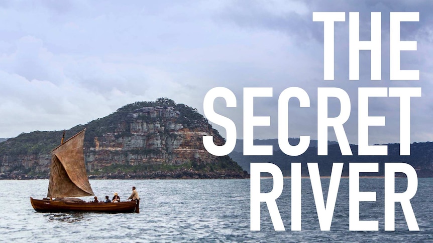 Boat in the middle of a huge body of water, behind it is a cliff