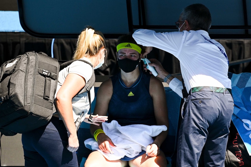 Karolína Muchová sits down on Rod Laver Arena as she receives treatment.