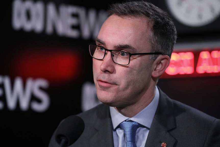 Tim Storer answers a question during an interview on AM, wearing a grey suit and blue tie.