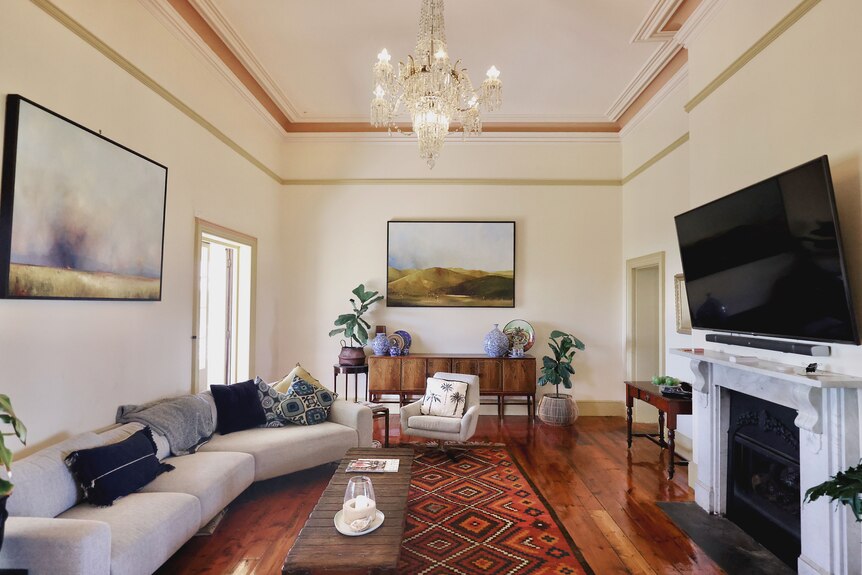 A large cream living room with artwork on the walls.