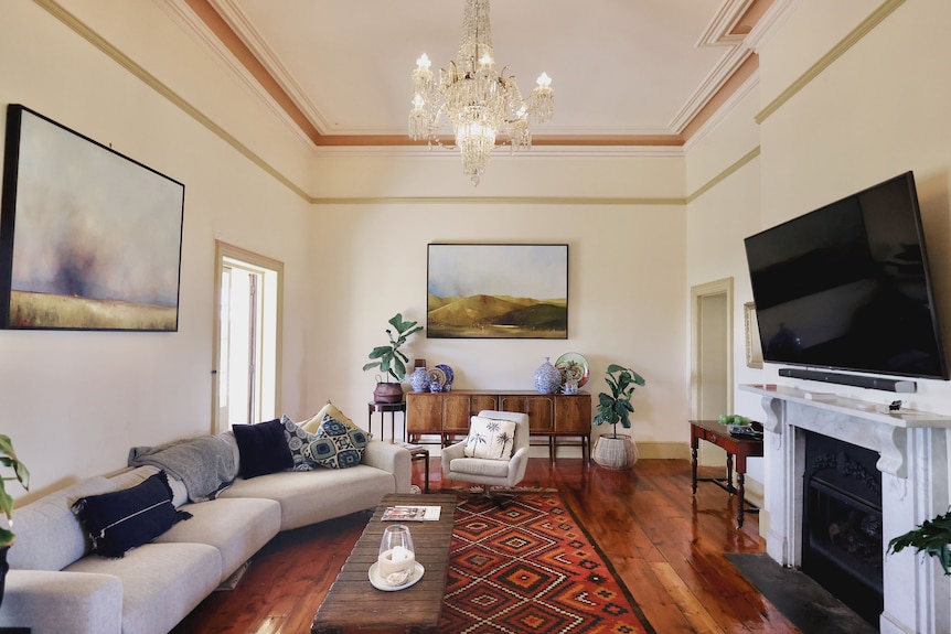 A large cream living room with artwork on the walls.