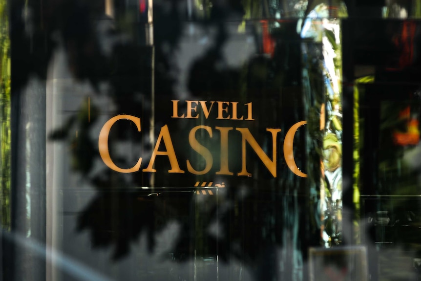 A sign on a black door in gold lettering which says level one and casino.