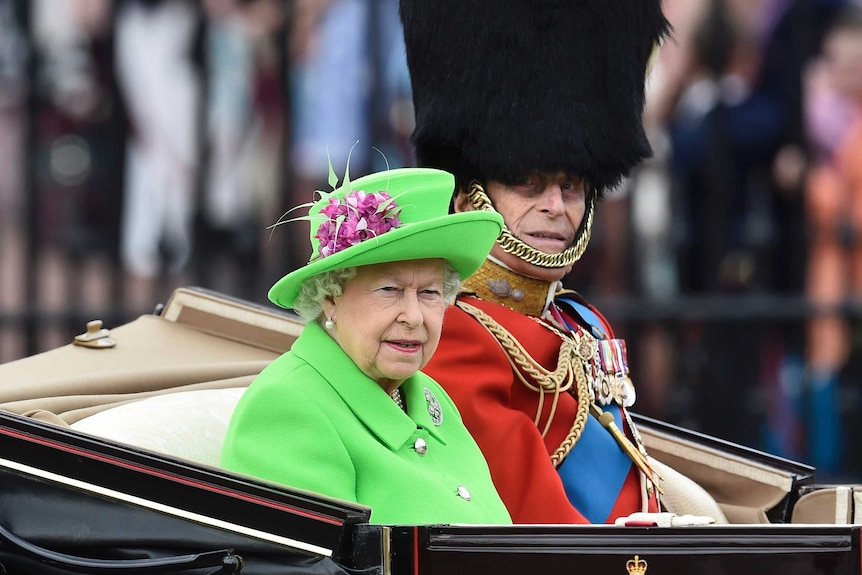 Queen Elizabeth and Prince Philip travel in a carriage to Horseguards Parade for the annual Trooping the Colour.