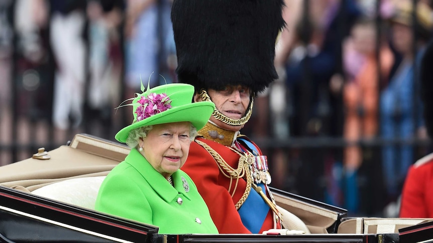 Queen Elizabeth and Prince Philip travel in a carriage to Horseguards Parade for the annual Trooping the Colour.