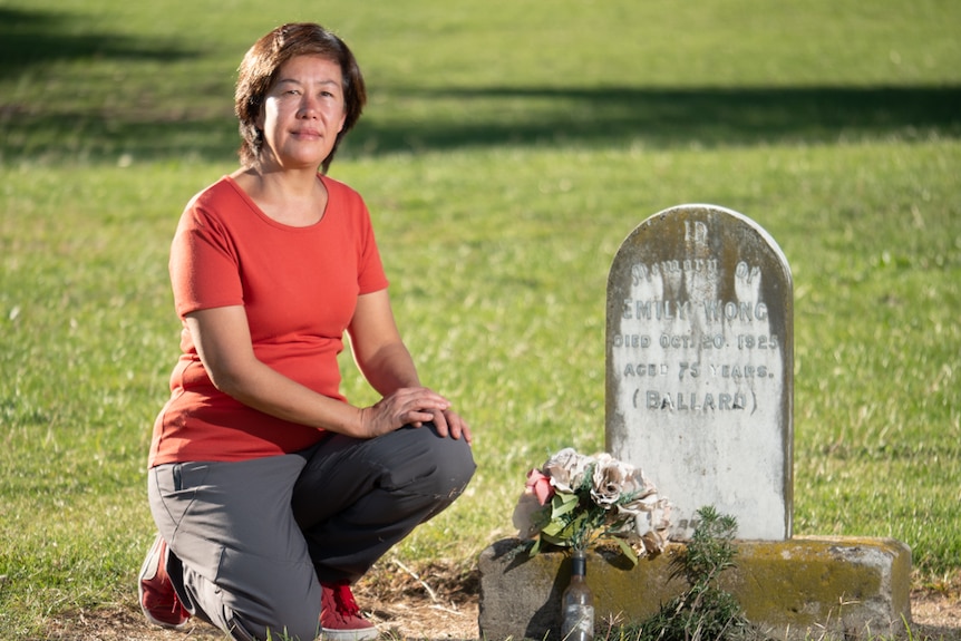 Juanita Kwok kneeling beside a gravesite
