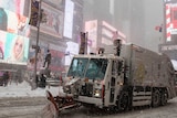 A snow plough drives through a quiet New York Times Square.