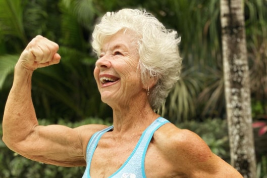 Older woman posing to show the muscles in her right arm 