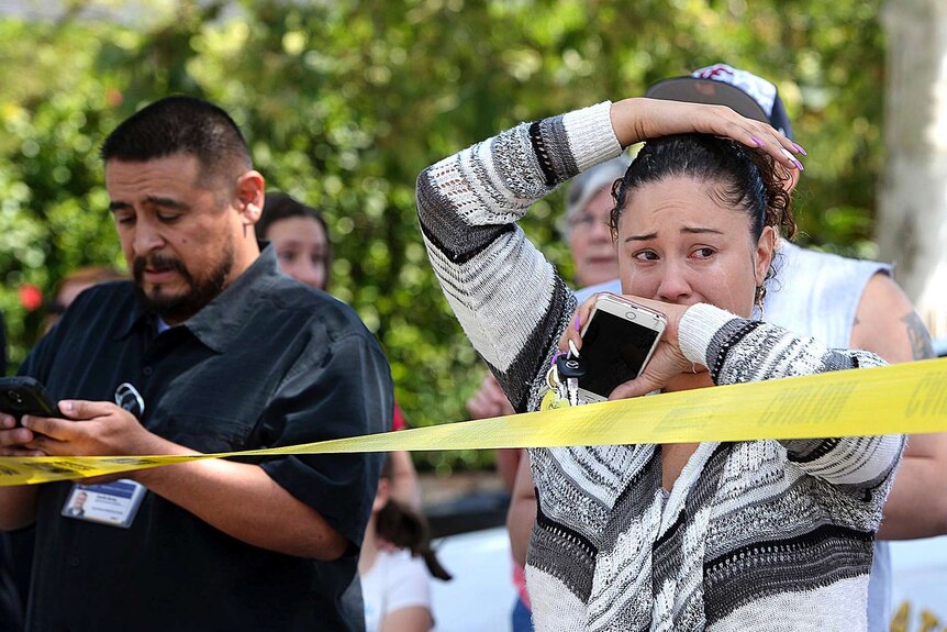 Families of students stand behind police tape after a school shooting in San Bernardino