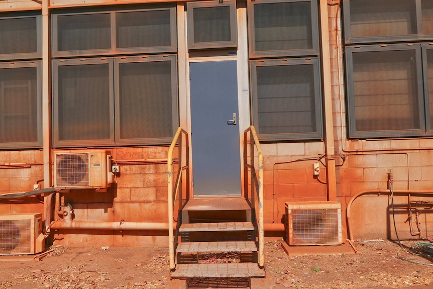 The outside of a building covered in reddish dust.