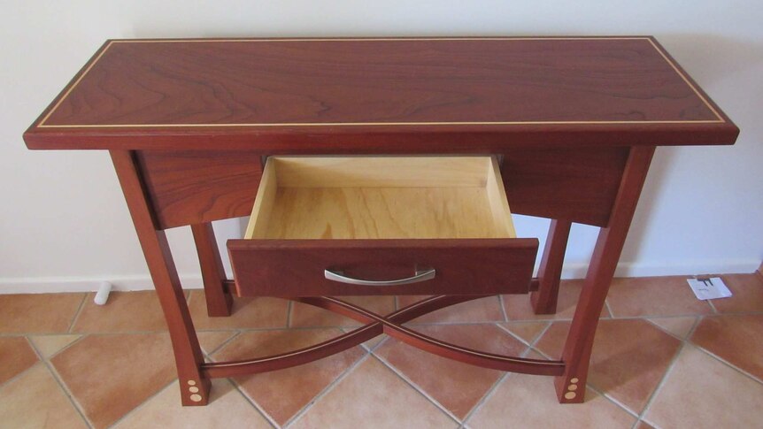 A red cedar table with one drawer open.