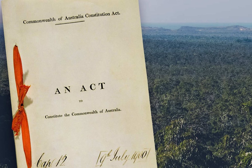 A ribbon bound version of Australia's constitution with a photo of the Australian outback in the background.