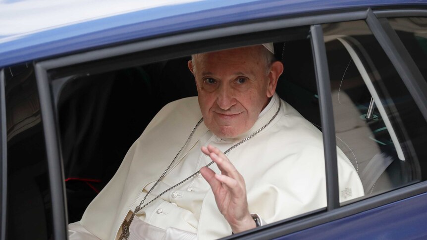 Pope Francis waves from a car window