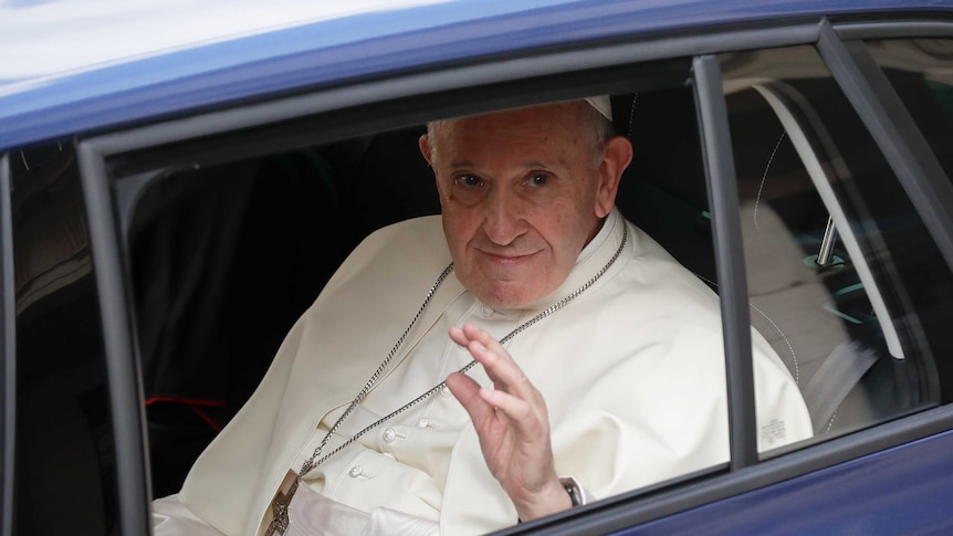 Pope Francis waves from a car window