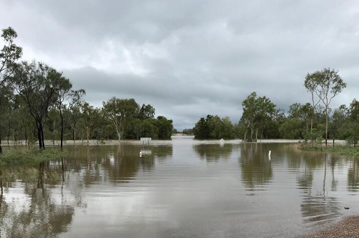 Flooded road and cane paddocks at Barratta Creek near Clare, south of Townsville