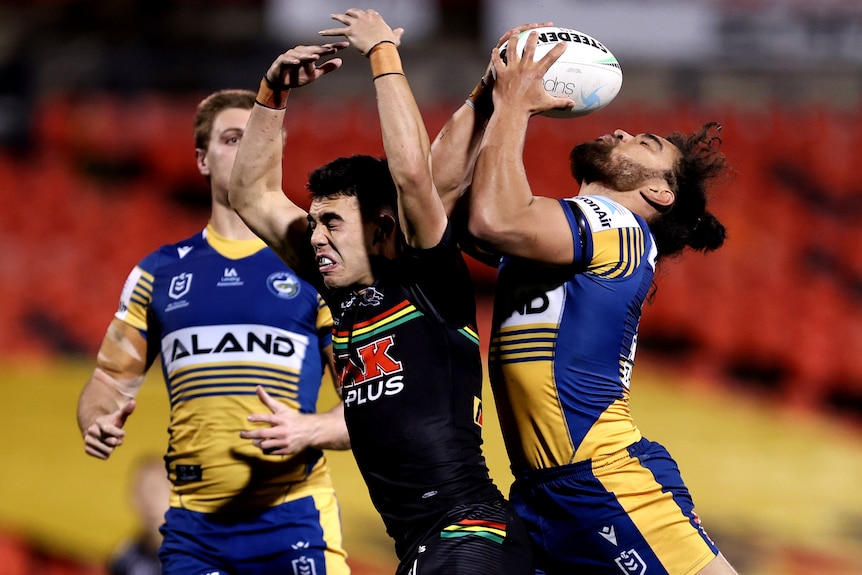 A Parramatta Eels NRL player attempts to catch the ball against Penrith.
