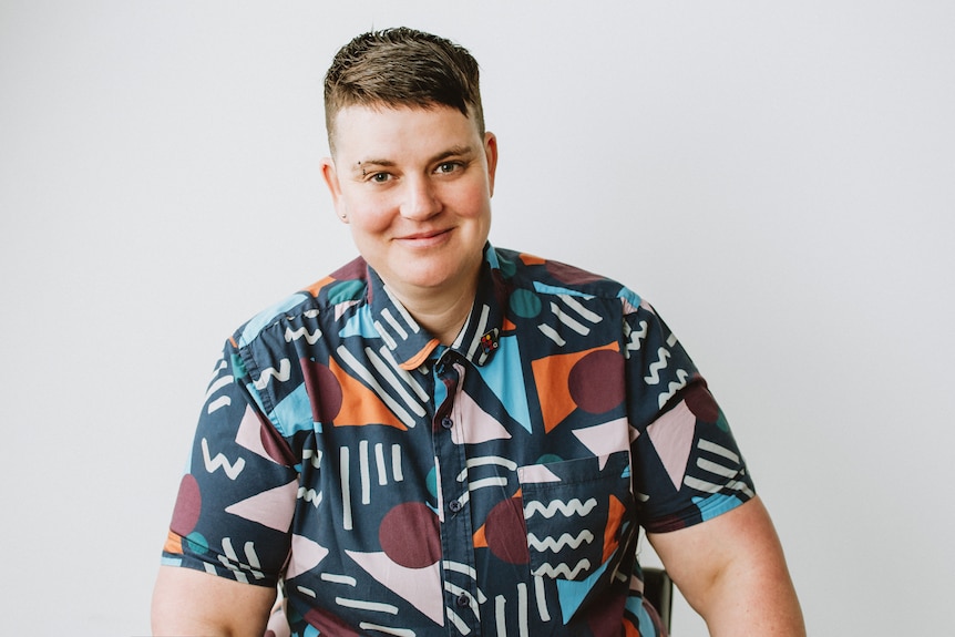 Joe Ball poses for a photo wearing a bright geometric-print shirt