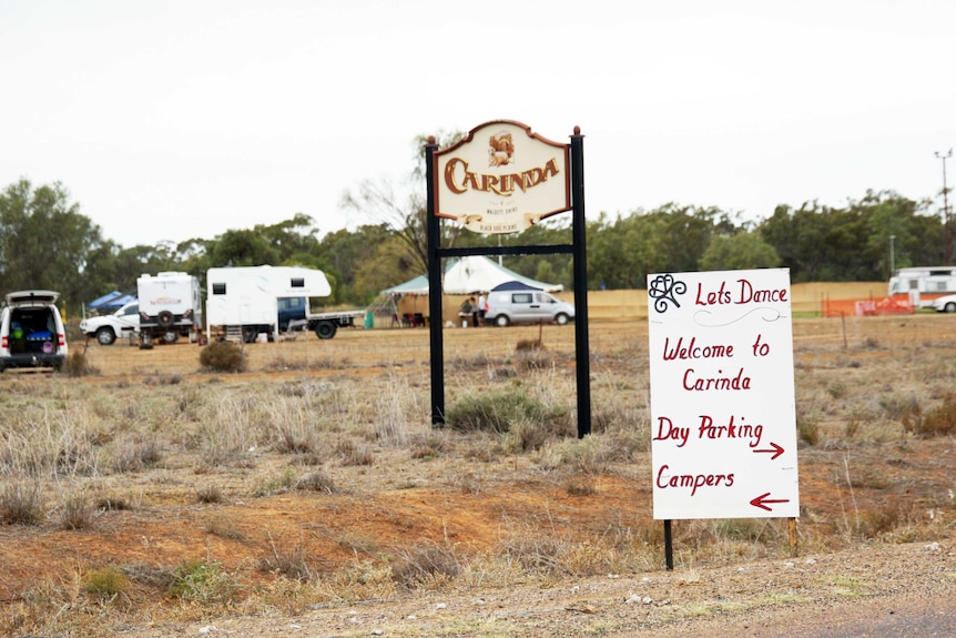 A handwritten sign welcomes visitors to Let's Dance Carinda, and a sign in the background welcomes visitors to the town itself.