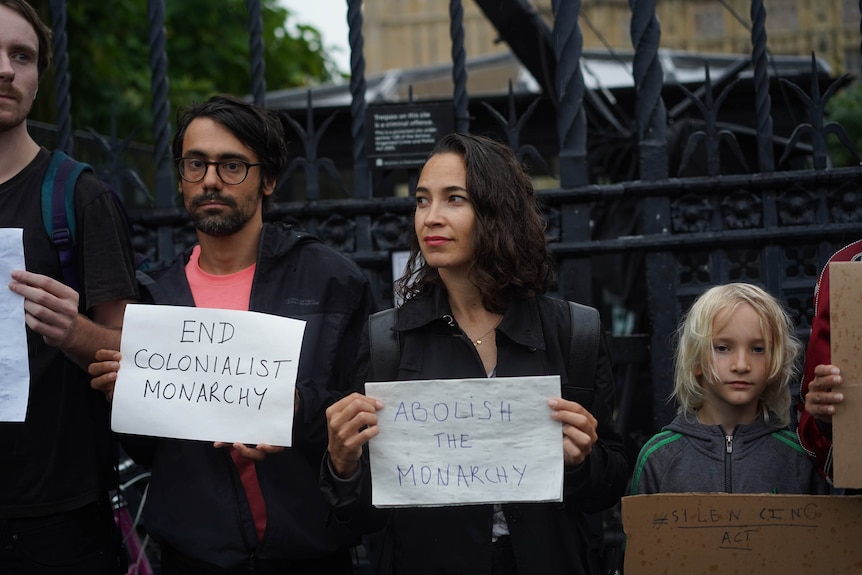 Alex holds a sign next to Judy