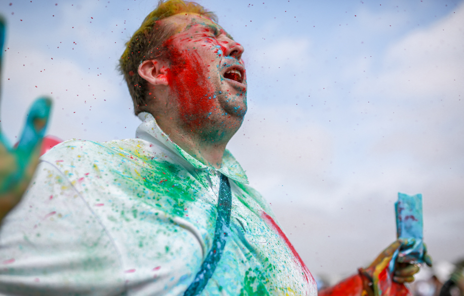 A man being sprayed with coloured powder