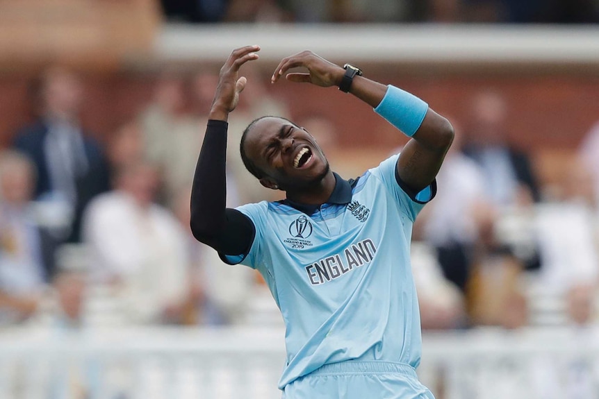 Jofra Archer closes his eyes, opens his mouth and raises his arms as he contorts himself in an anguished expression