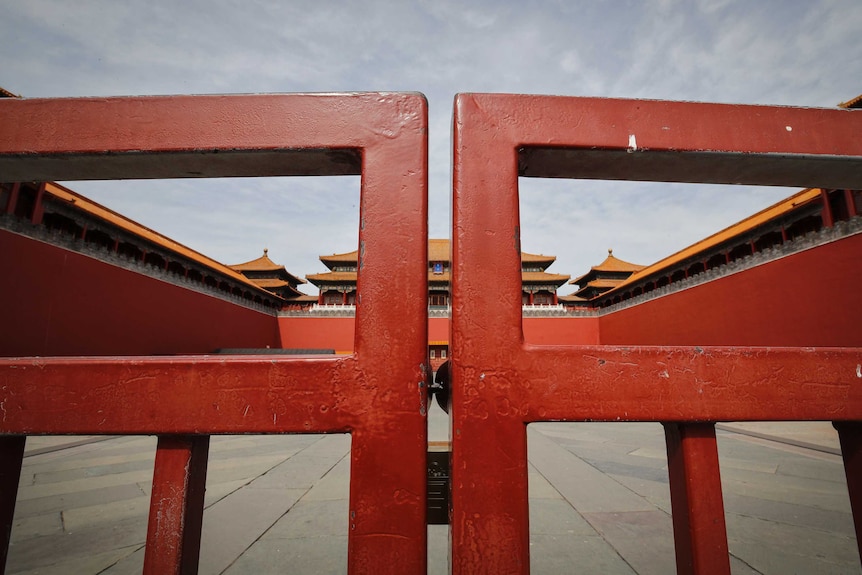 A close up of closed red gates to the Forbidden City.