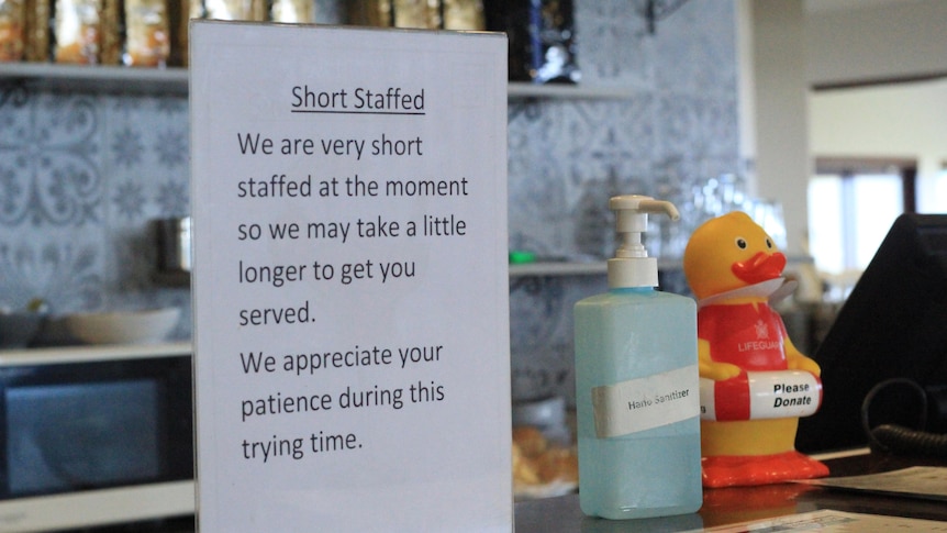 An A4 sign which says 'we are very short staffed at the moment so we may take longer to get you served'