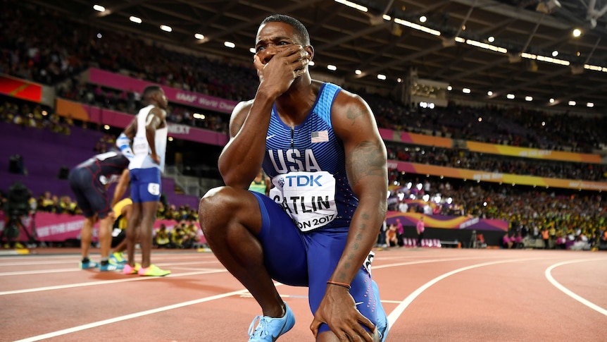 Justin Gatlin of the US kneels after winning the race.