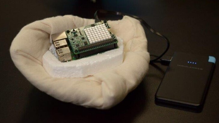 A breast prosthesis prototype with a built in microchip sits on a black table in front of a typical silicon breast prosthesis.