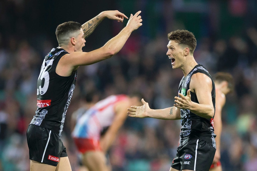 Jack Crisp holds his arms up and looks at Brody Mihocek who has his arms out ready for a hug.