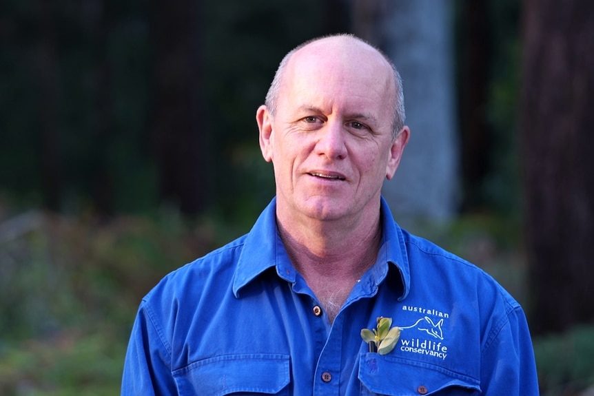 Dr John Kanowski wears a blue Australian Wildlife Conservancy shirt