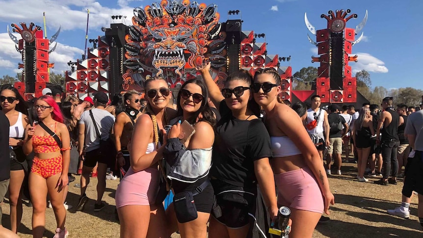 A group of young women pose in front of a stage