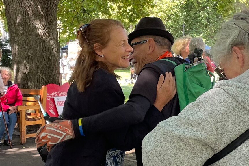 Susan Neill-Fraser hugs a man on parliament lawns in Hobart