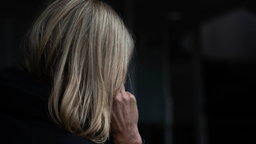 A woman sitting in the dark.