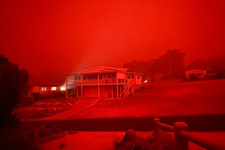 A red haze over a house in Mallacoota during bushfires.