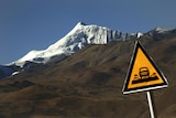 A road sign is seen in front of the Kharola glacier