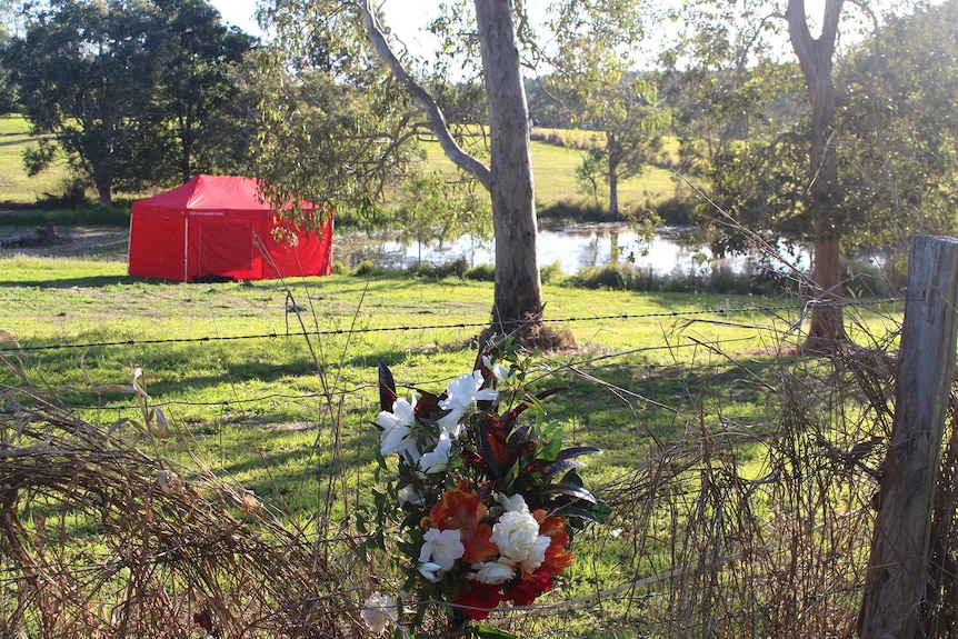 Flowers left on a fence near the dam where a 3yo girl drowned.