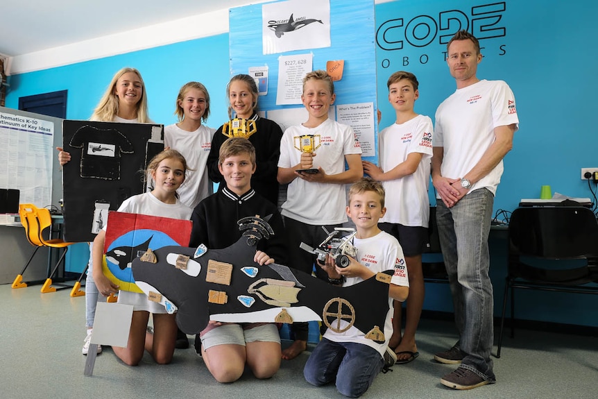 Students from iCode New Dawn with a cardboard cut-out orca
