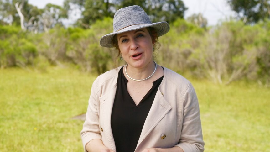 Associate Professor Natalie Warburton stands in field