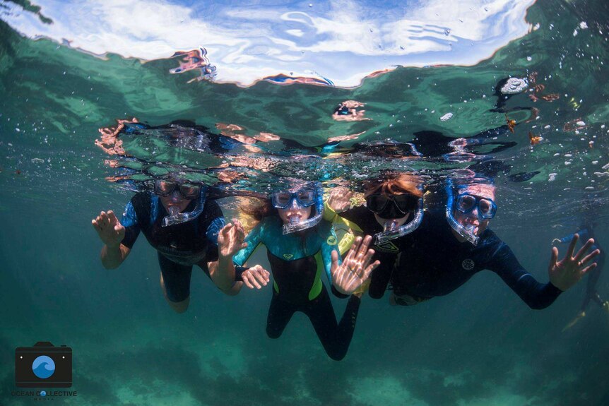 Israel Smith snorkelling with his two children and wife.